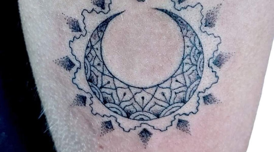 Close-up detail of ornamental moon dotwork tattoo showing fine line precision