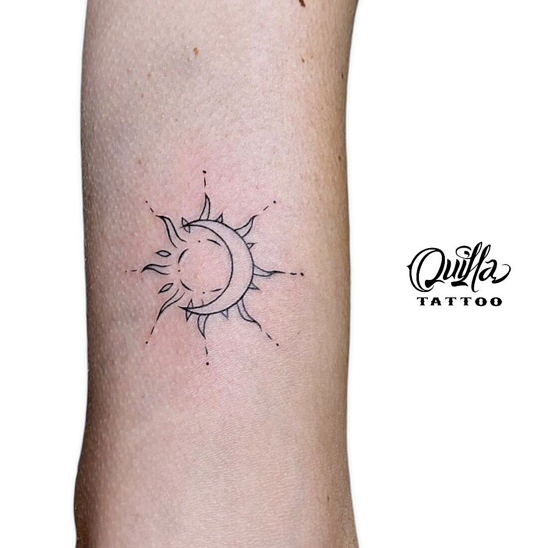 Minimalist sun and moon fine line tattoo on arm by Quilla Tattoo